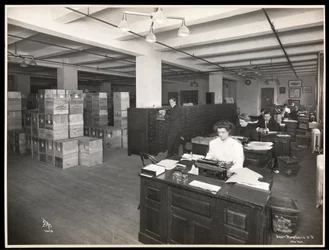 View of men and women at desks in what appears to be a shipping room at Parke, Davis and Co., chemists, Hudson and Vestry Streets, New York, 1910